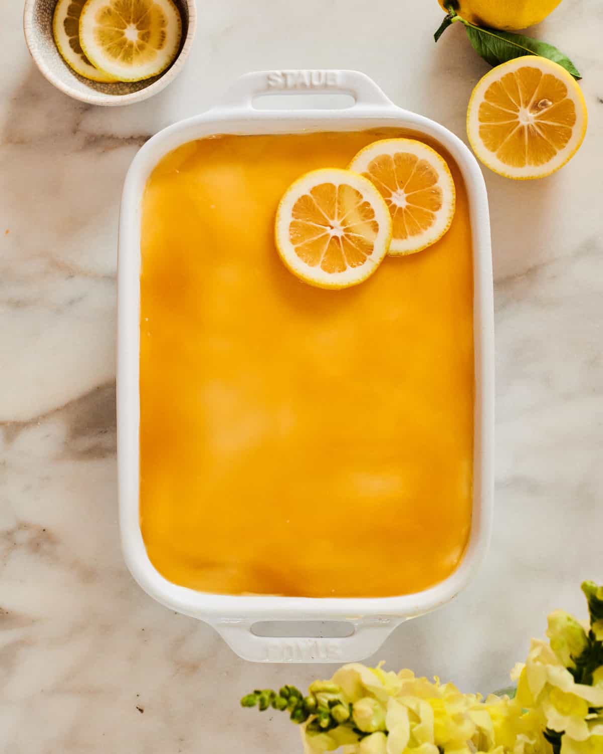 Limoncello Tiramisu in baking dish with lemons on top.