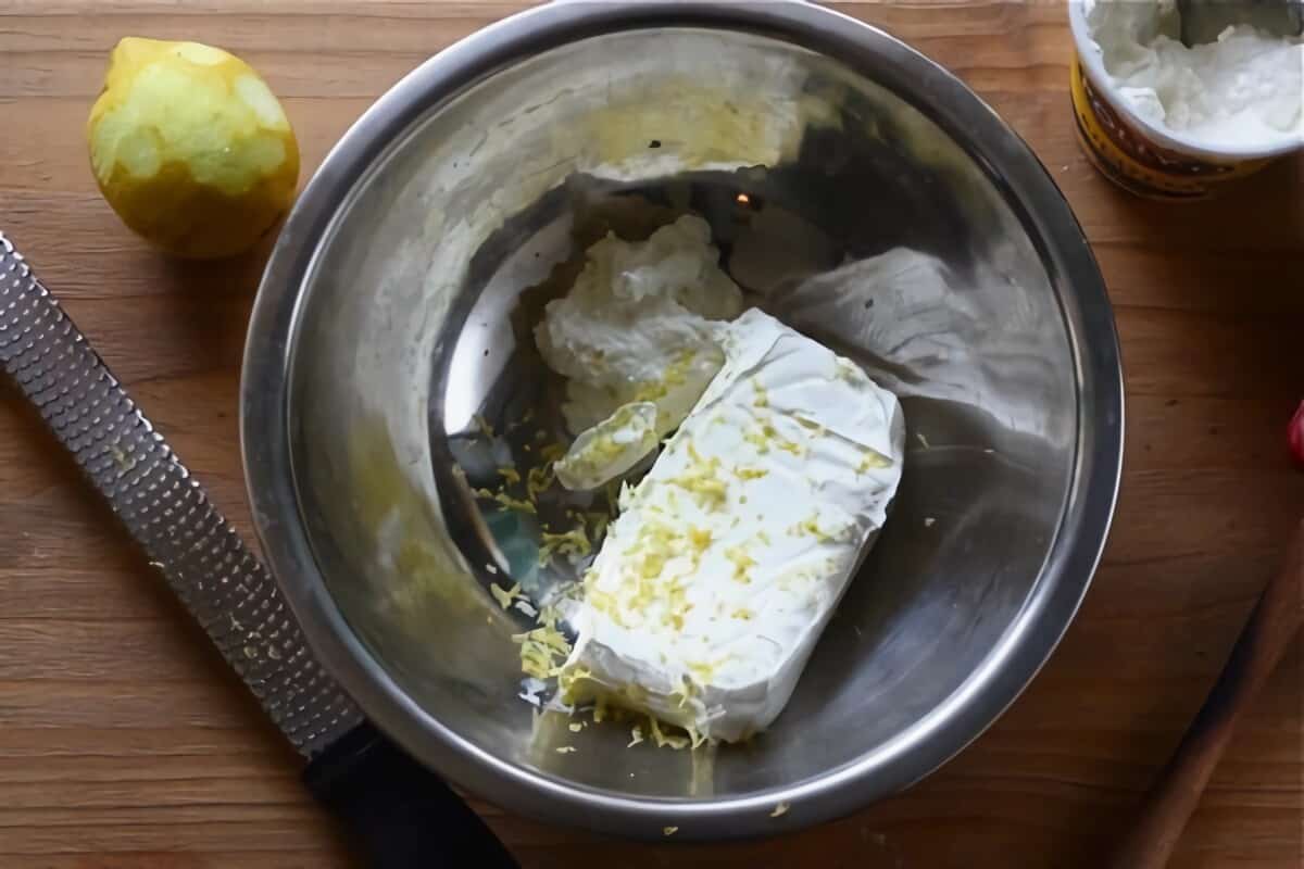 Cream cheese in a bowl with lemon zest.