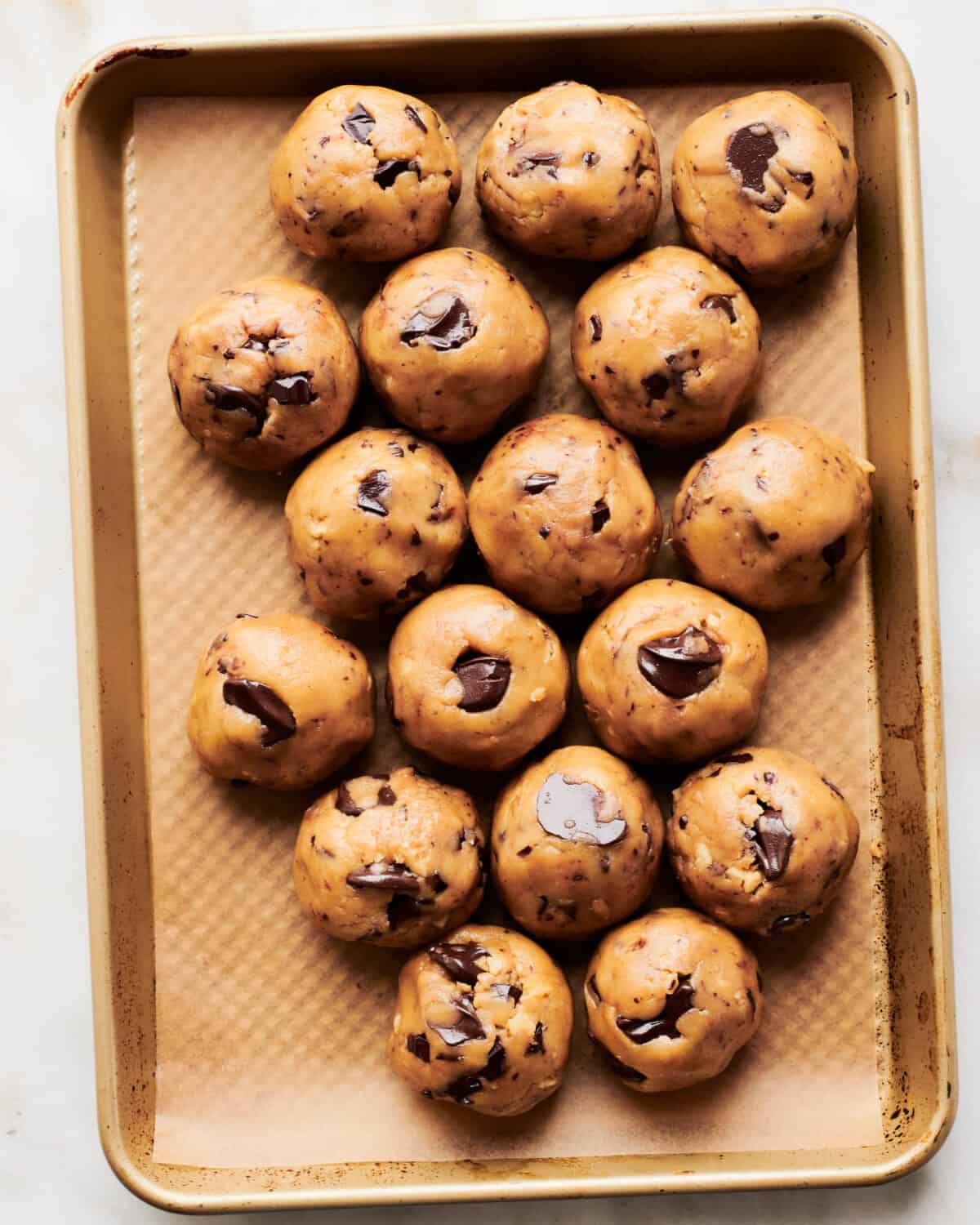 Cookie dough balls on a baking sheet. 