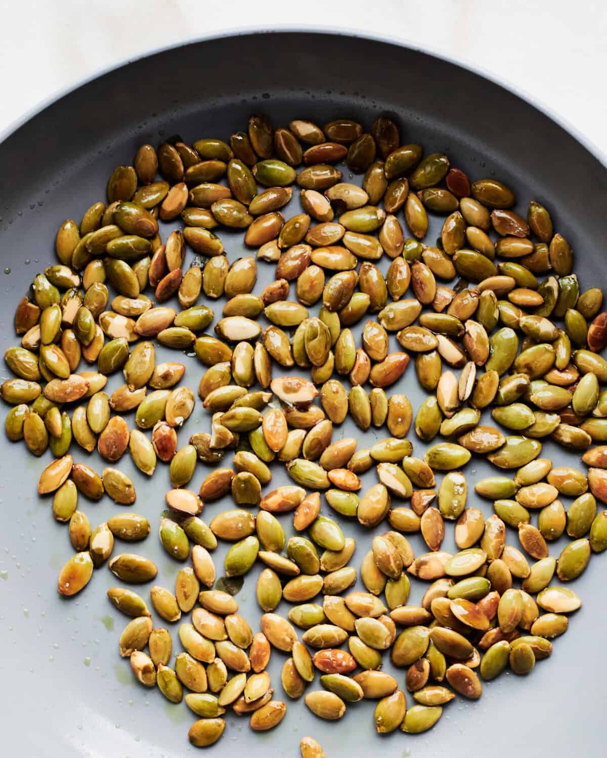 Pumpkin seeds toasting in a pan. 