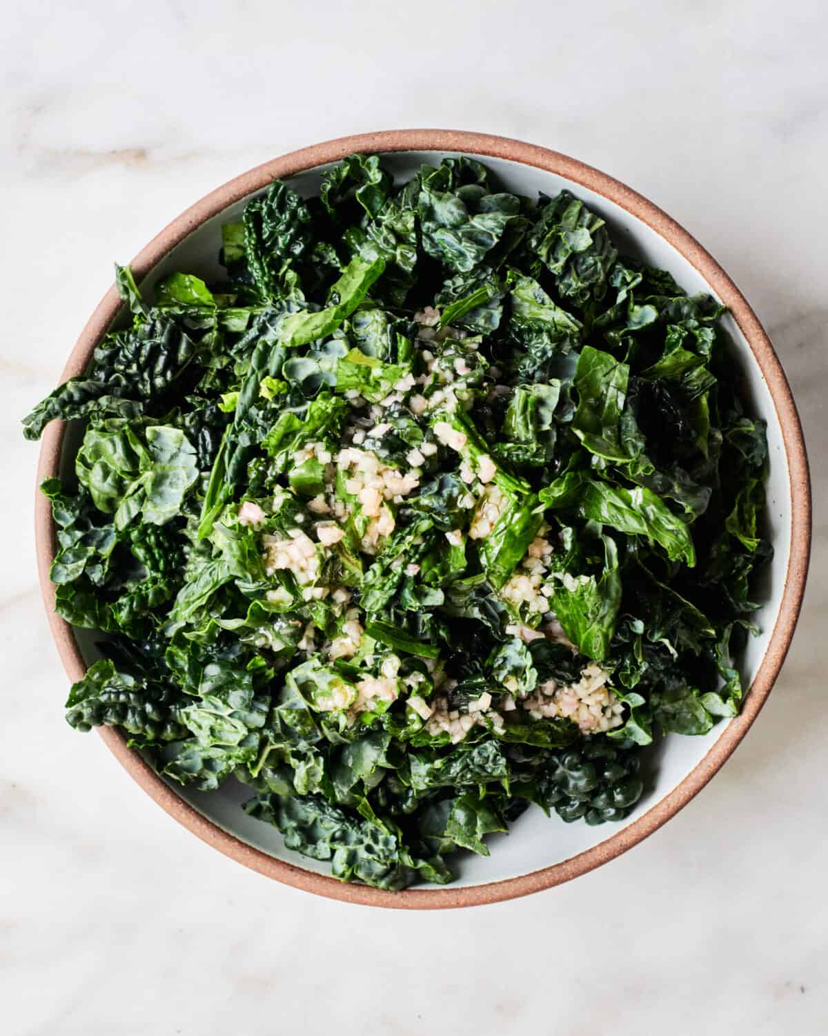 Kale with dressing on top in bowl. 