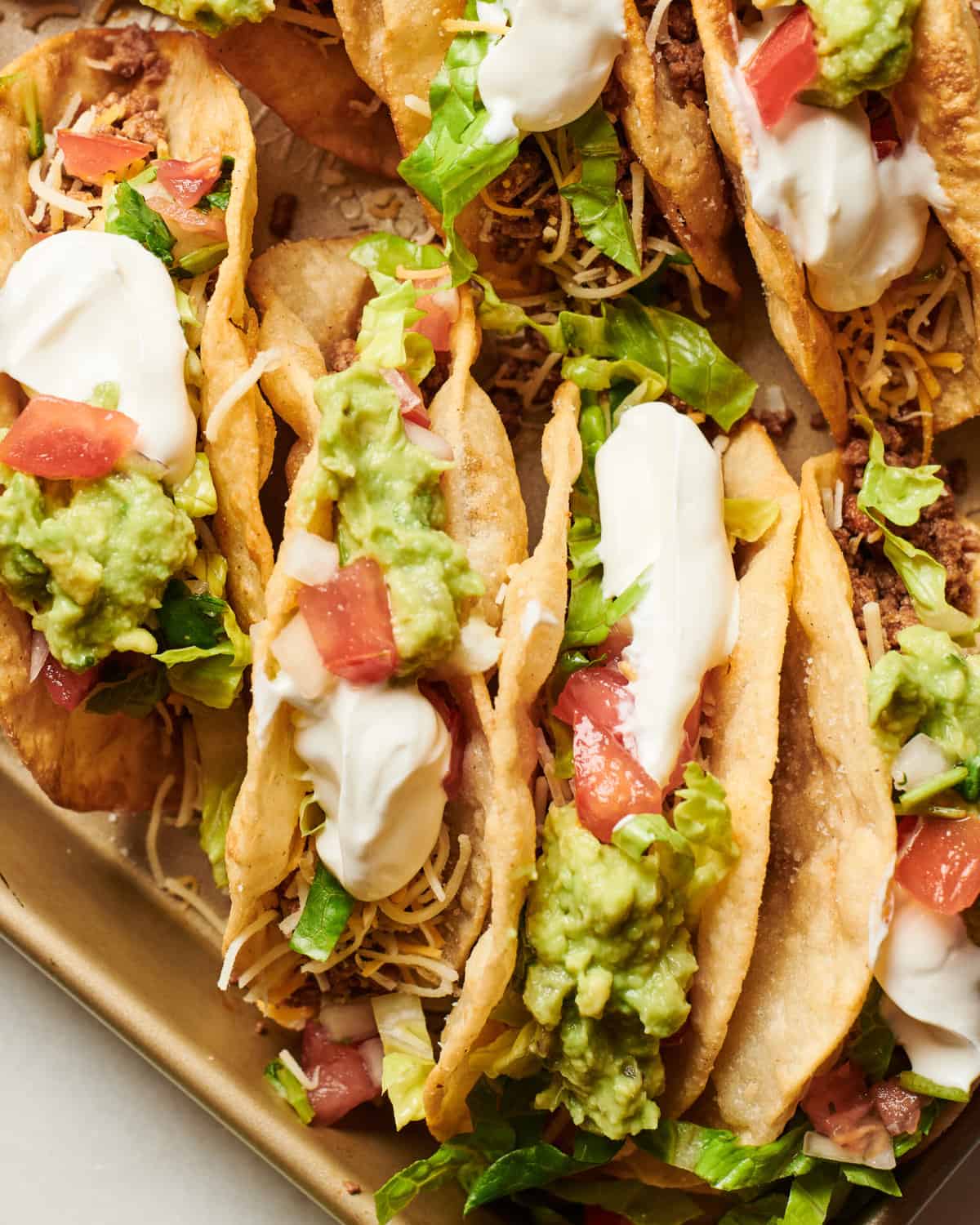 Ground Beef Tacos in puffy shells on a baking sheet. 
