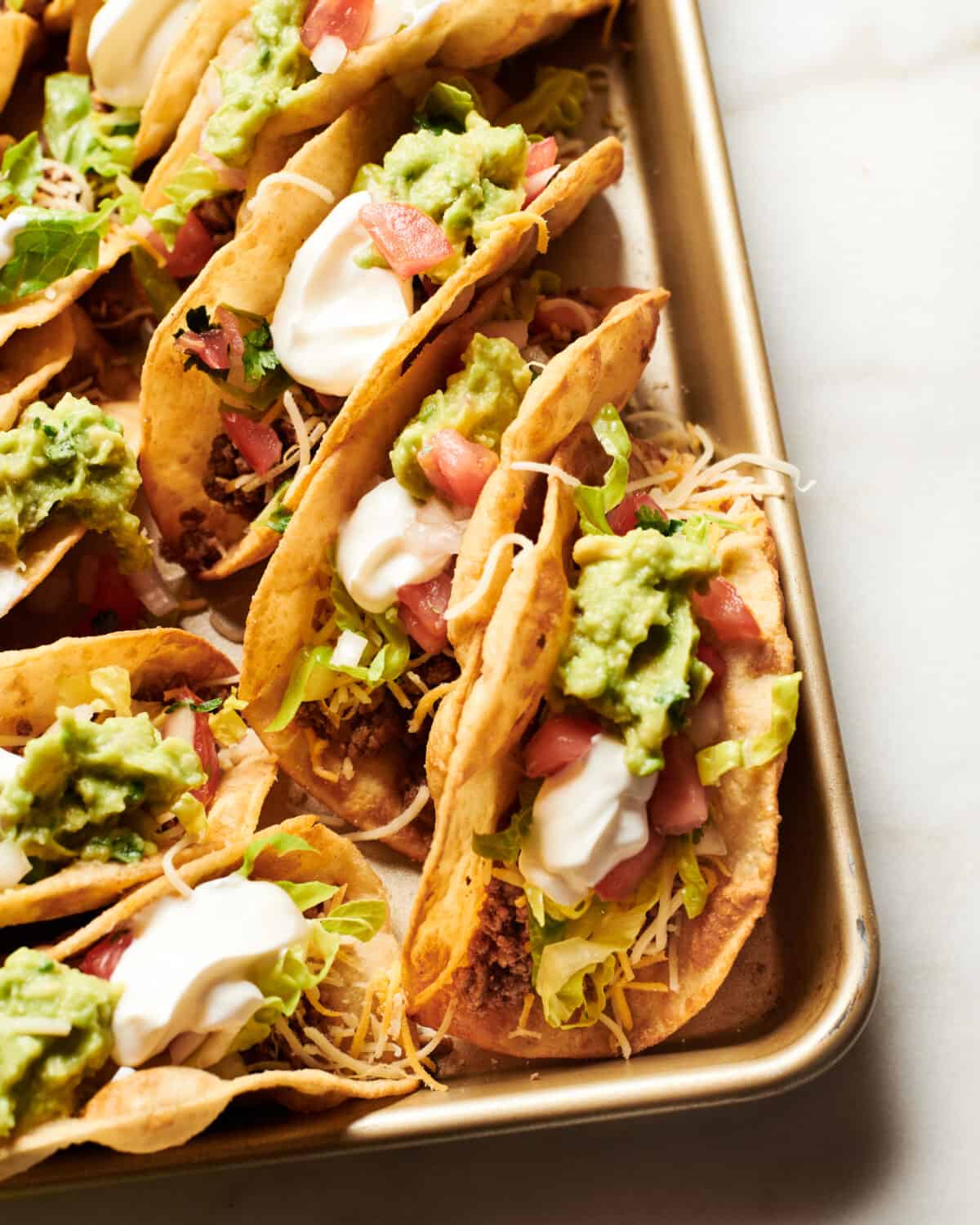 Ground Beef Tacos in puffy shells on a baking sheet. 