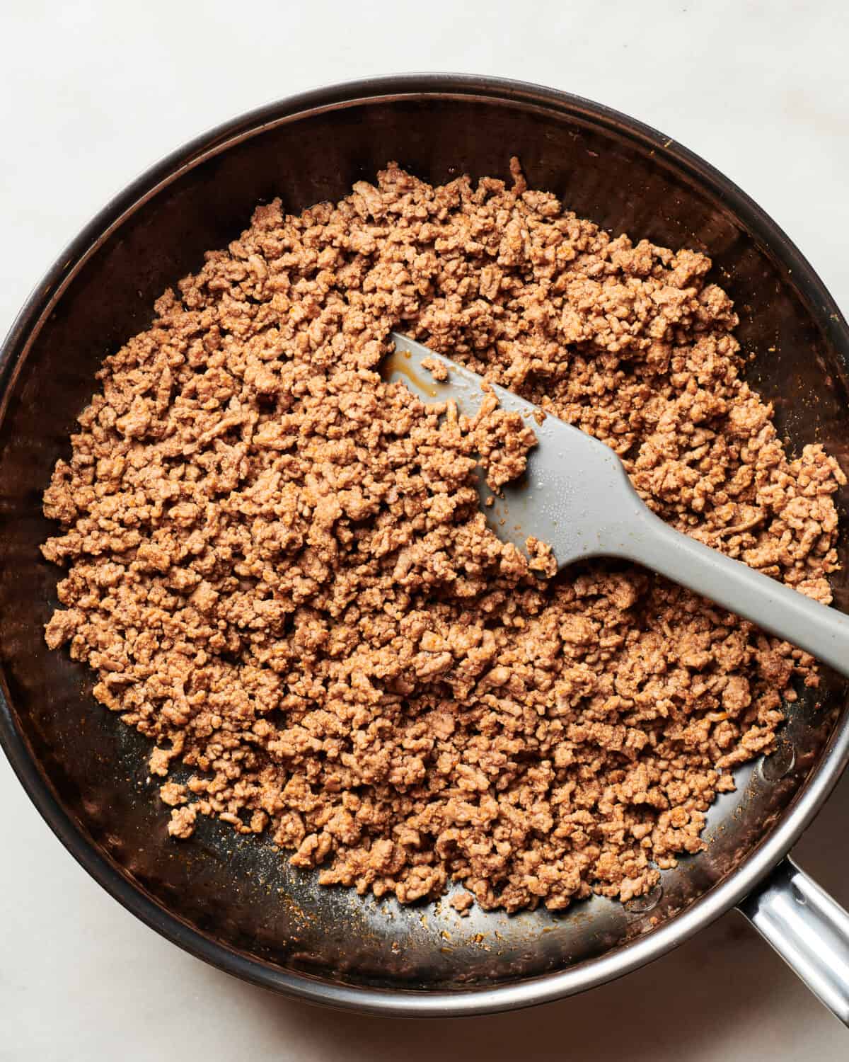 Ground beef browned in a pan. 