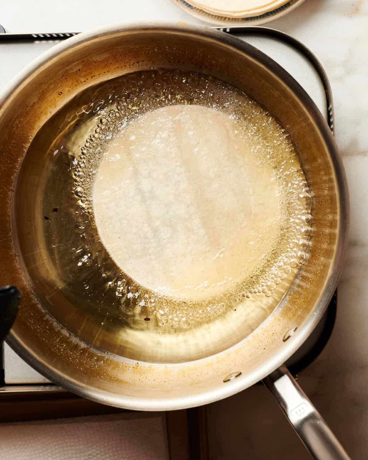 Tortilla in a pan bein fried. 