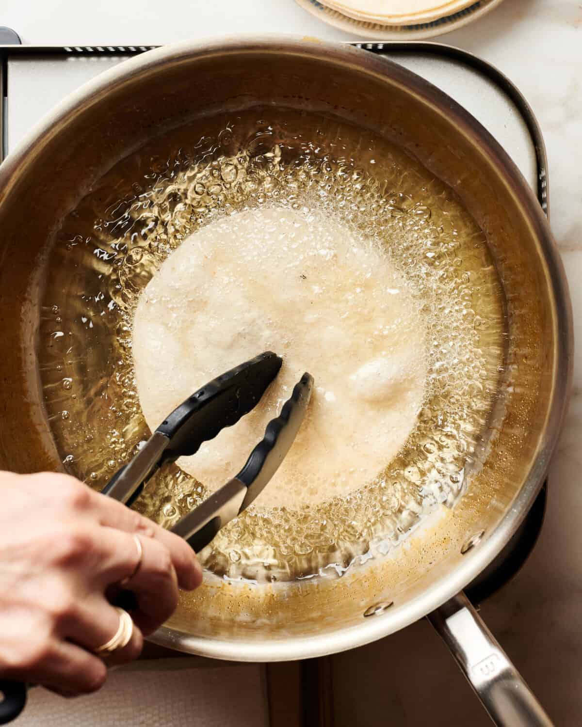 Frying a tortilla in a pan. 