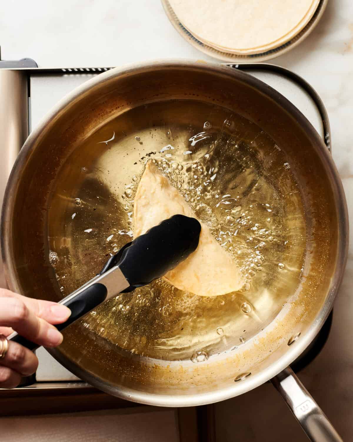 Frying taco shells. 