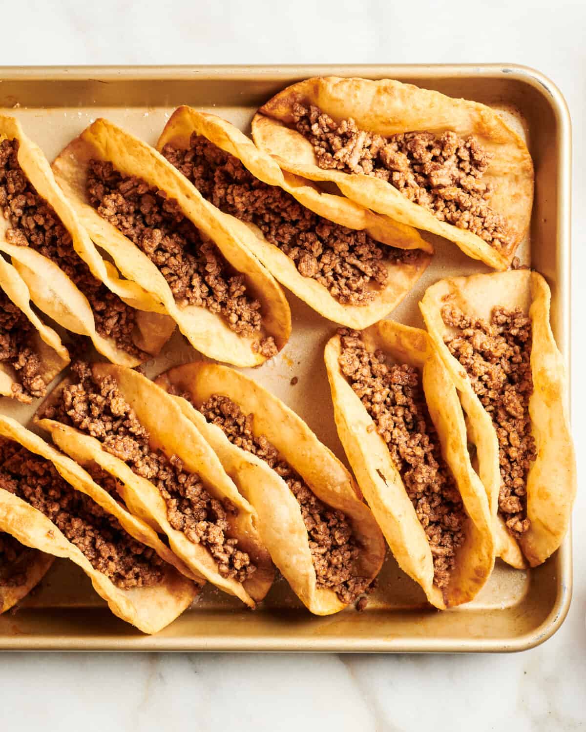 Ground Beef added to taco shells. 