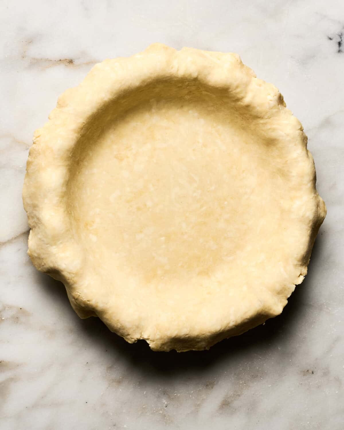 Rolled out pie crust placed in pie pan. 