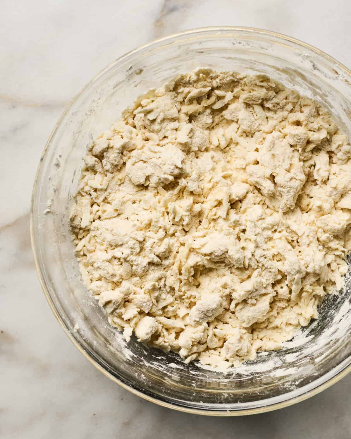 Dough being mixed together in a bowl. 