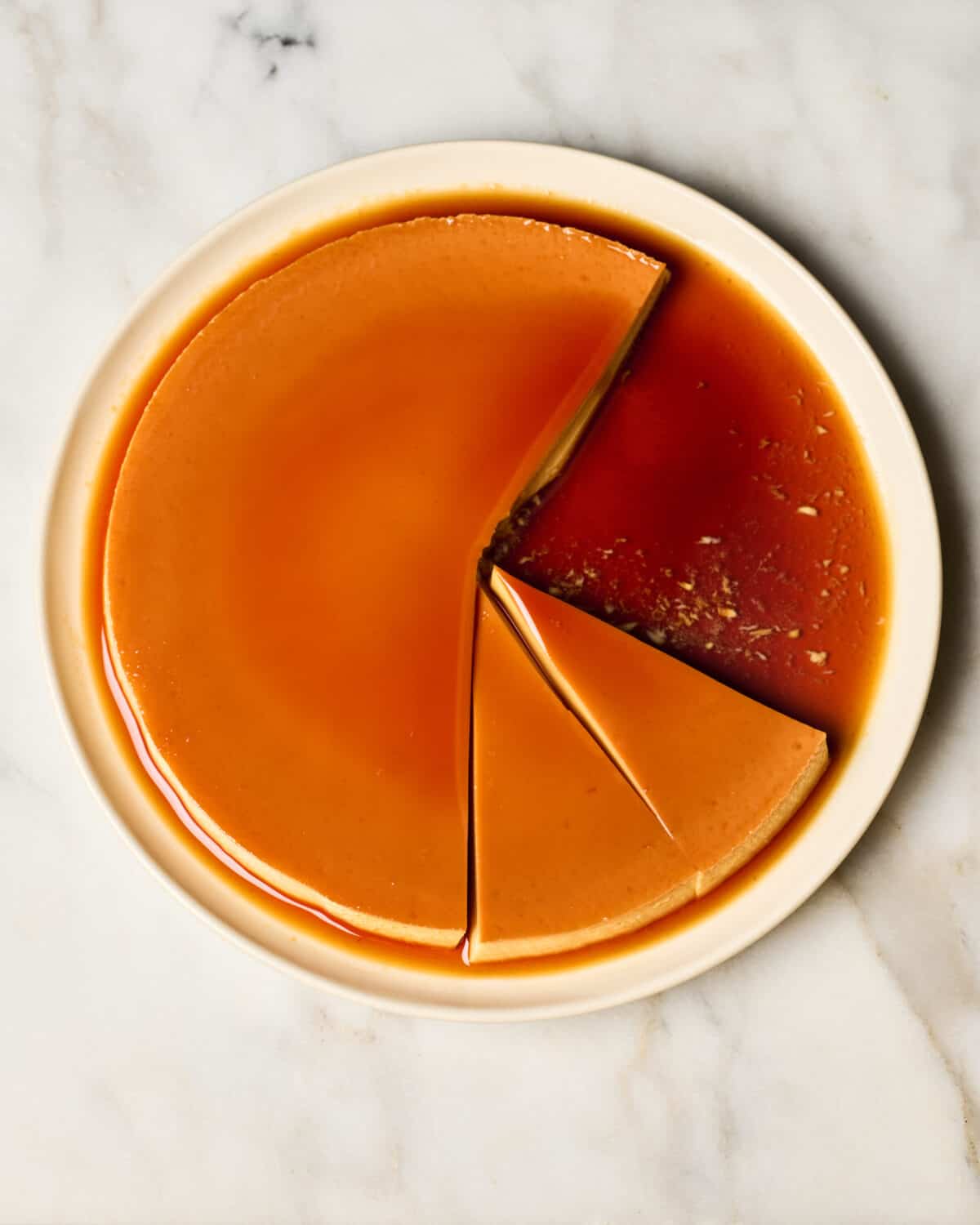 Flan on a plate all sliced up. 