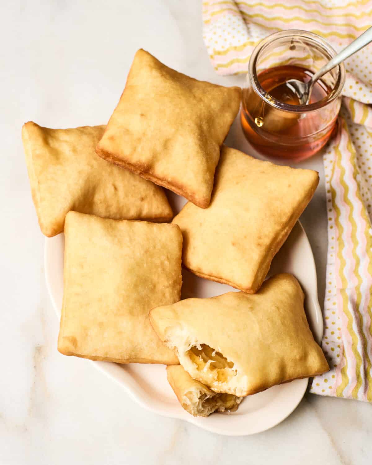 Sopapillas on a plate with honey. 