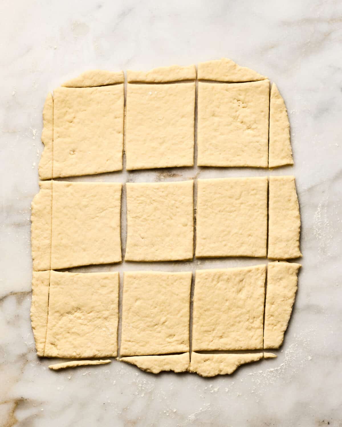 Dough being cut out in squares. 