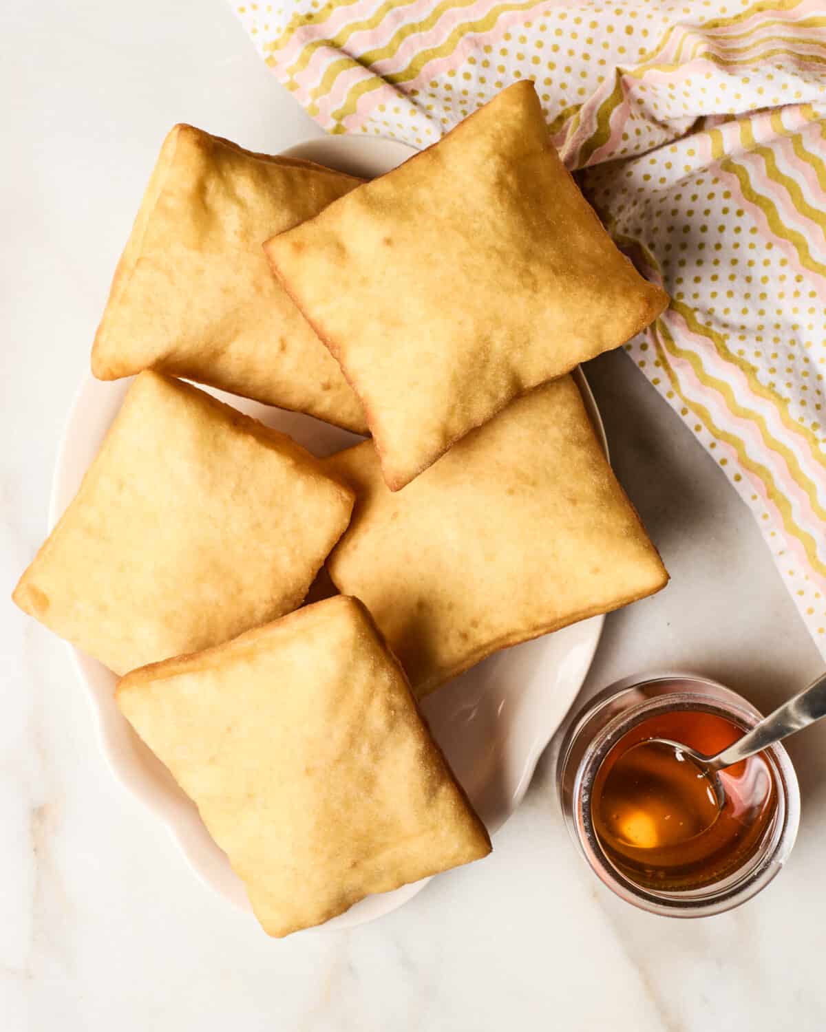 Sopapillas on a plate with honey. 
