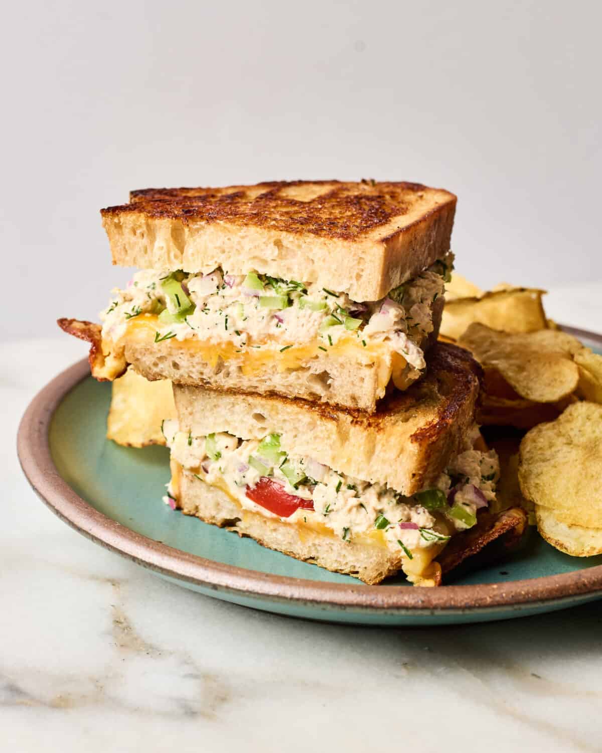 Tuna melt on a plate with chips. 