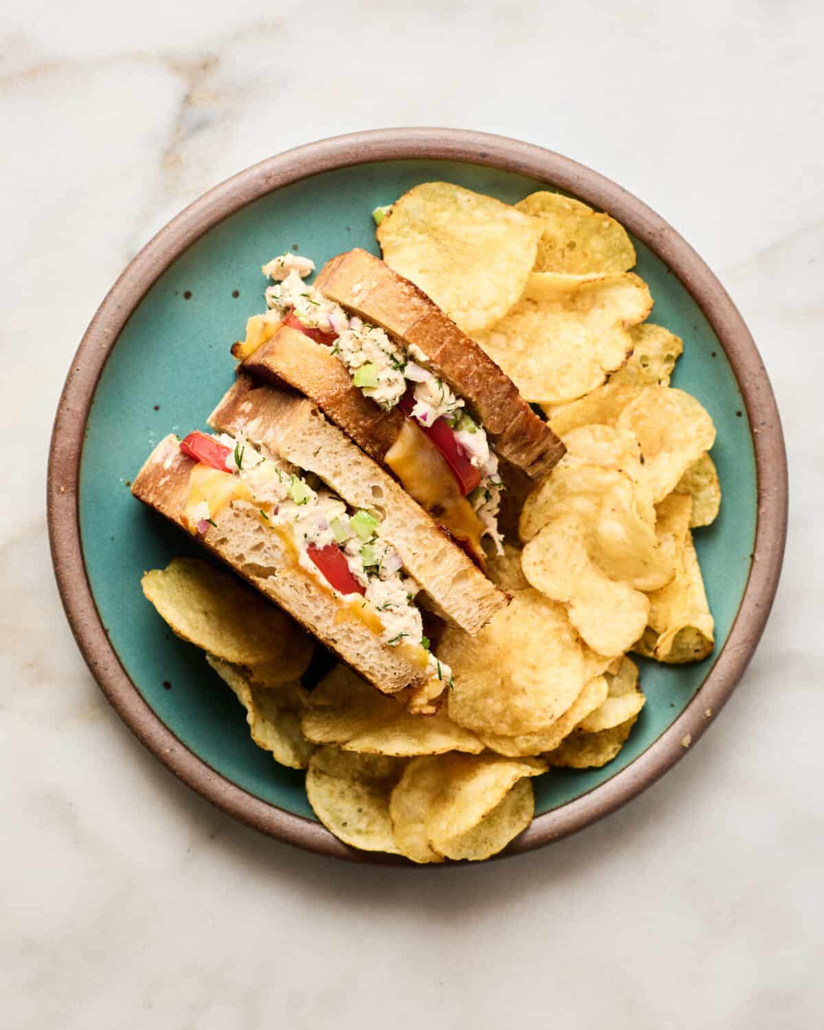 Tuna melt on a plate with chips. 