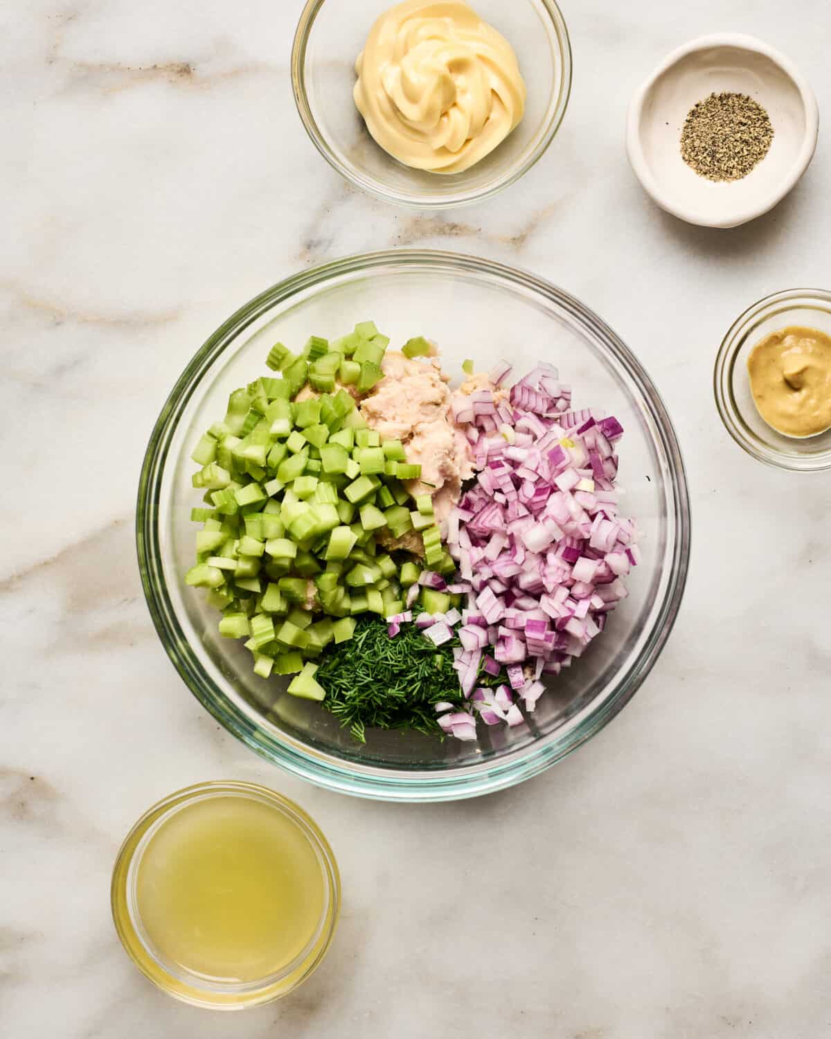 Tuna, red onion, celery, herbs in a bowl. 