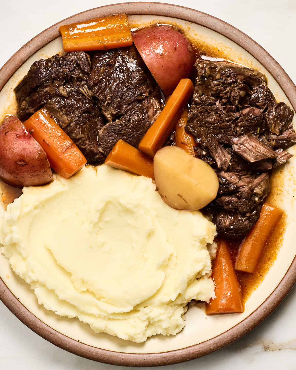 Pot Roast that is fork tender with mashed potatoes and carrots. 