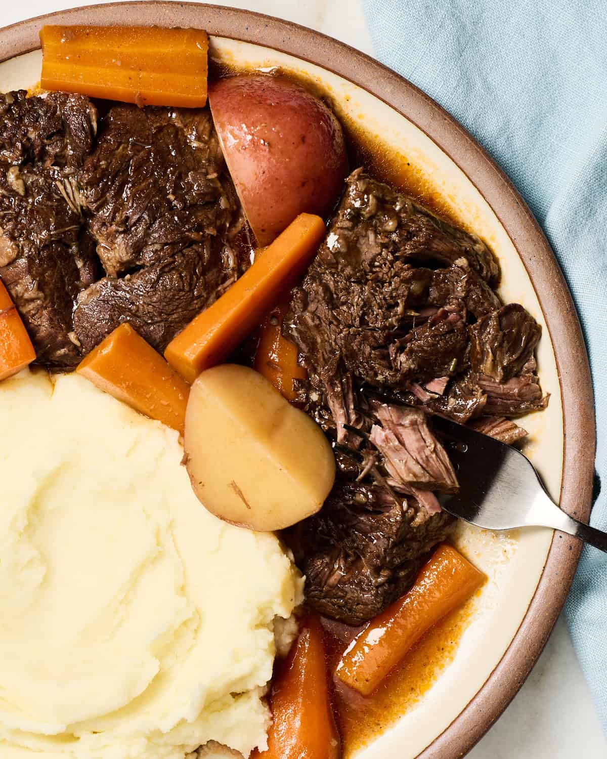 Pot Roast on a plate with mashed potatoes and carrots. 