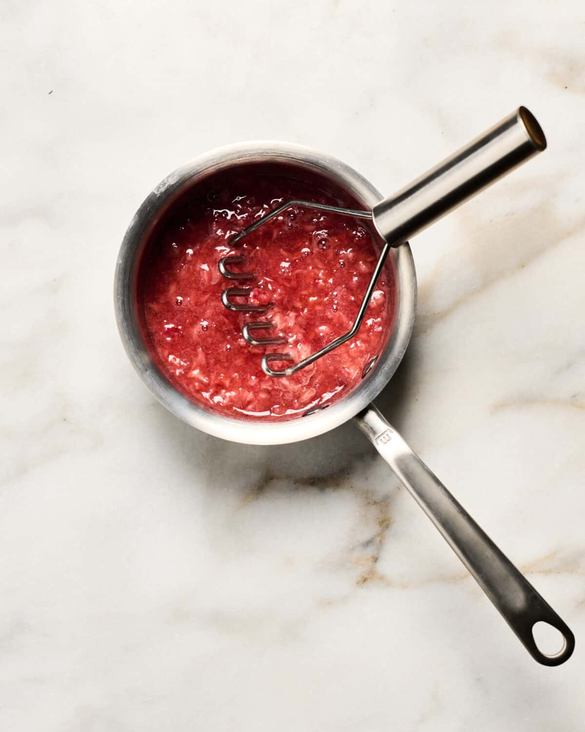 Cooking the strawberry glaze in pan. 