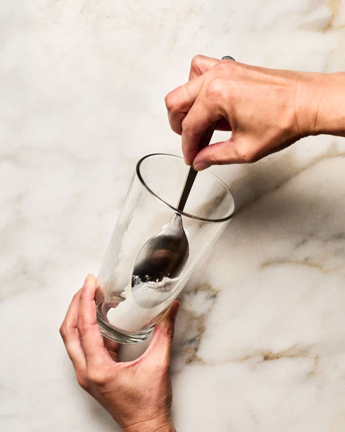 Adding coconut cream to the sides of the glass. 