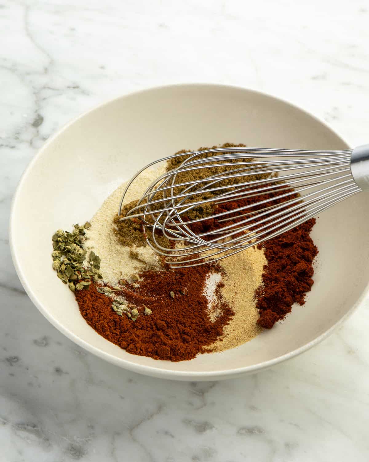 Spices being mixed together in bowl. 