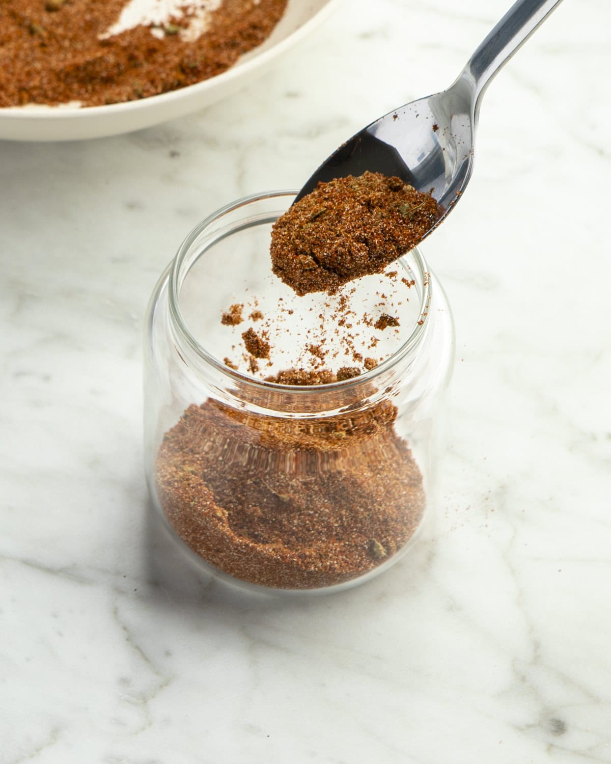 Taco Seasoning being added to jar. 