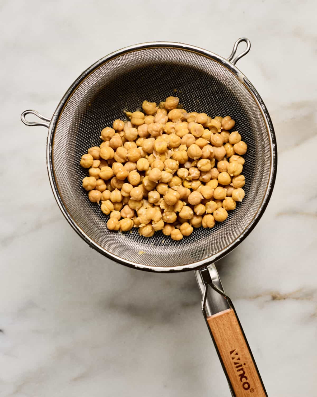 Draining cooked chickpeas. 