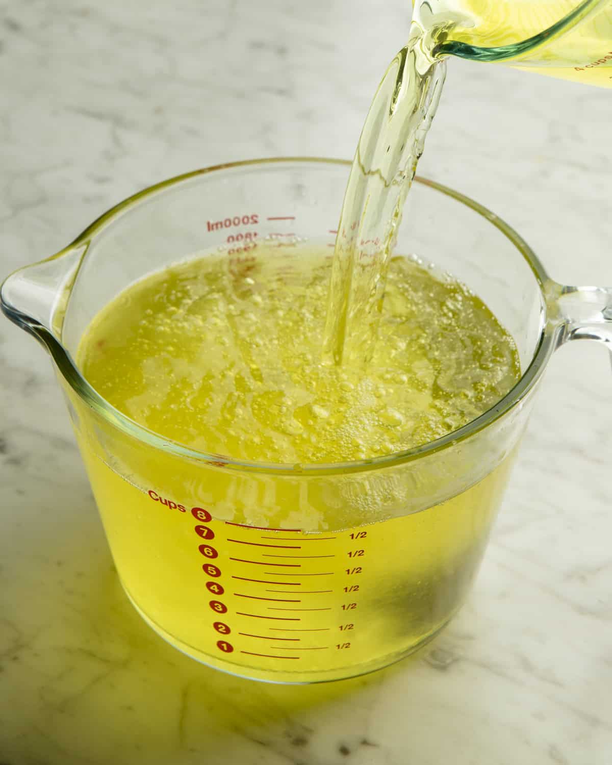 Limoncello mixture added to a large measuring cup. 