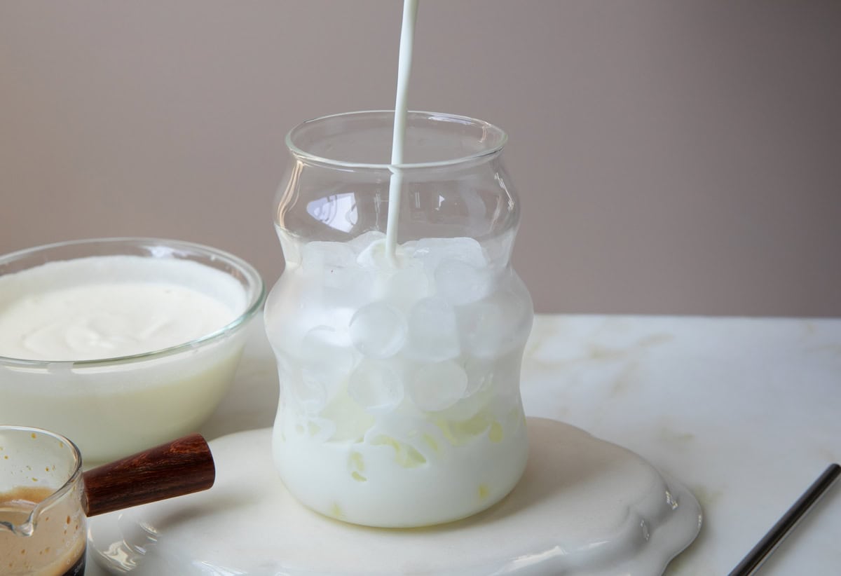 Milk being added to glass. 