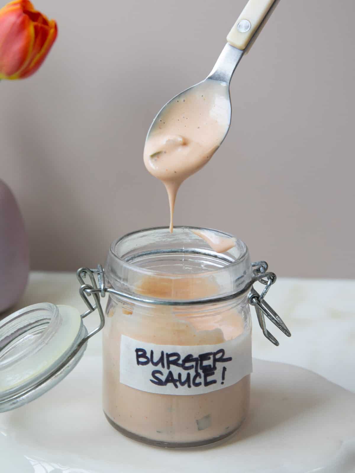 Burger Sauce in a jar with a spoon dipped inside.
