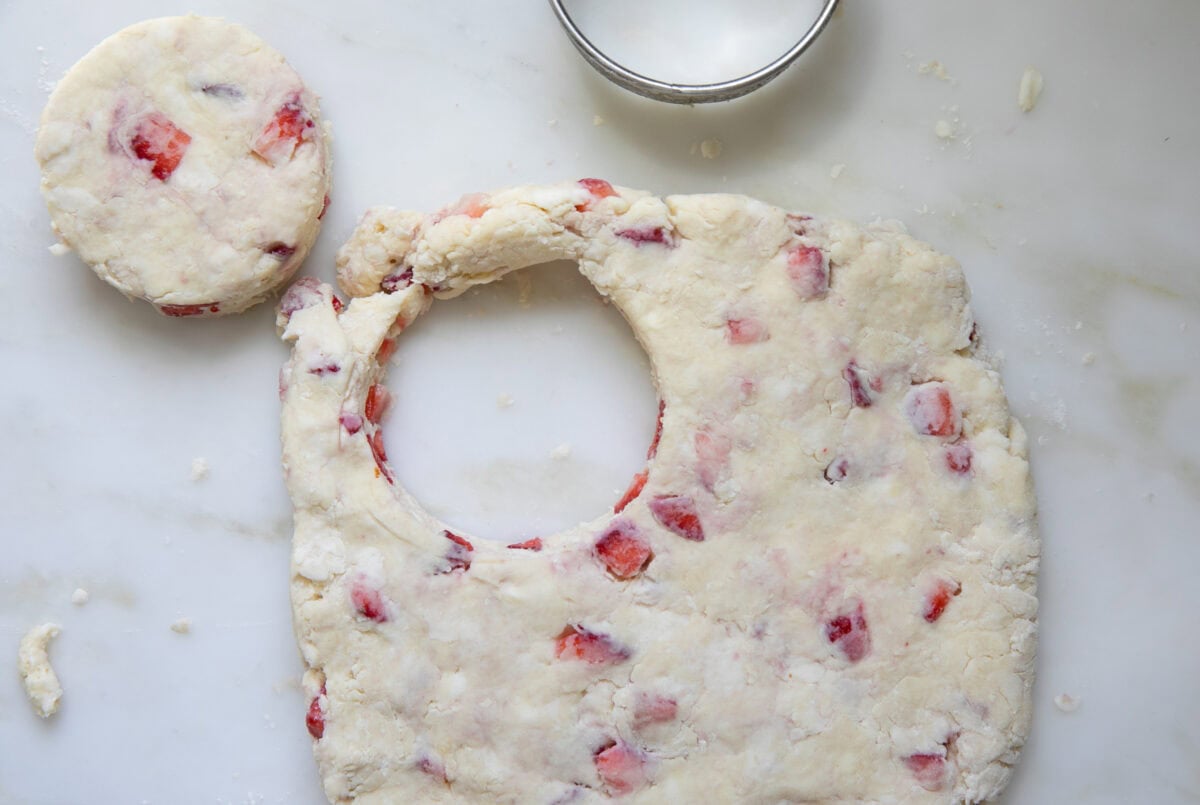 Strawberry Biscuits being stamped out using a biscuit cutter. 