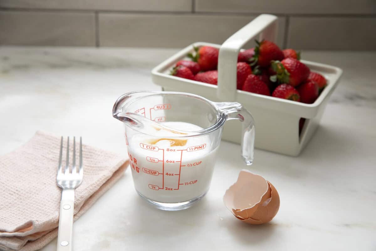 Egg being whisked with the buttermilk in a measuring cup. 