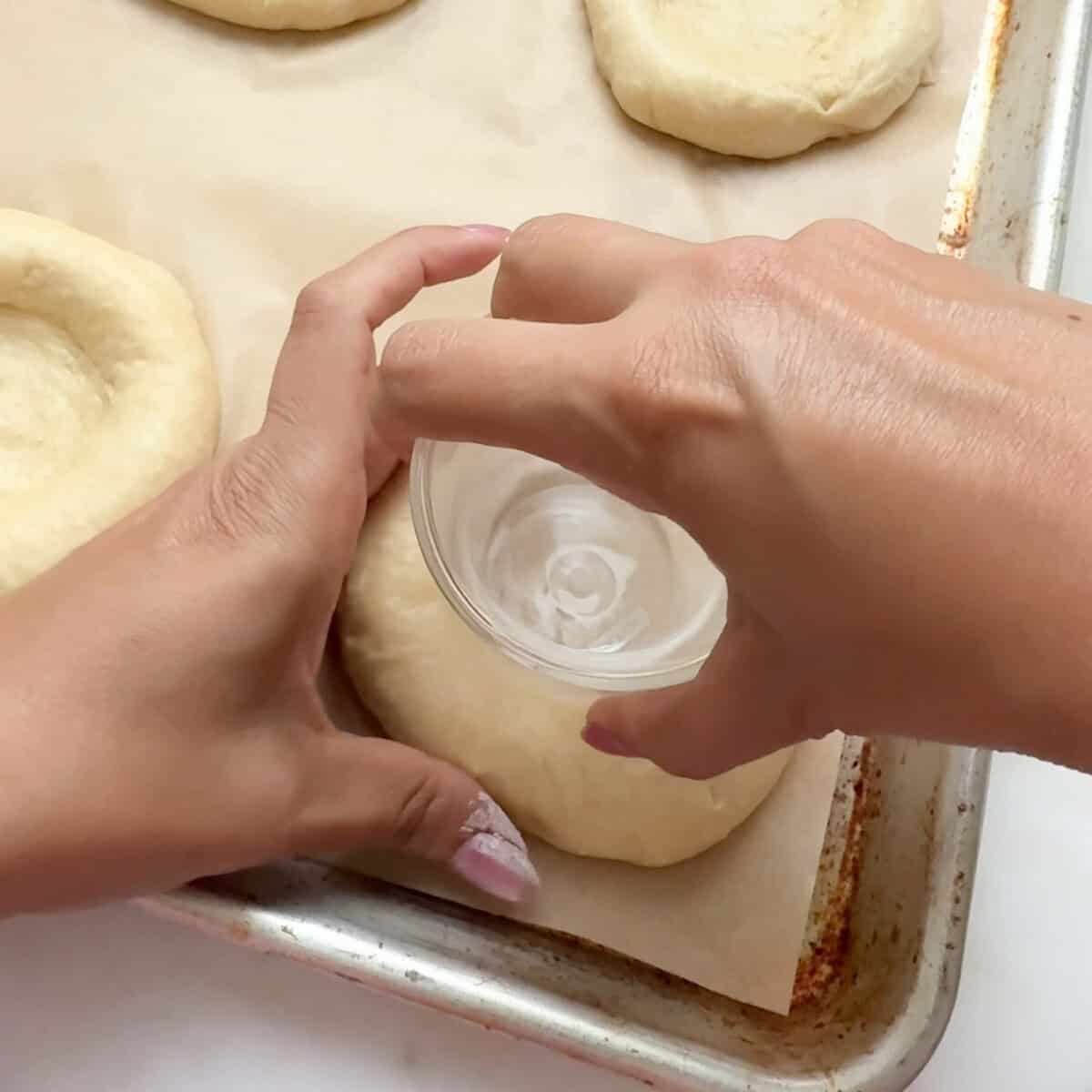 Shaping dough with glass.
