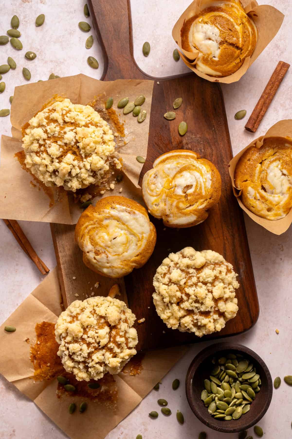 कटिंग बोर्ड पर कद्दू क्रीम चीज़ मफिन।