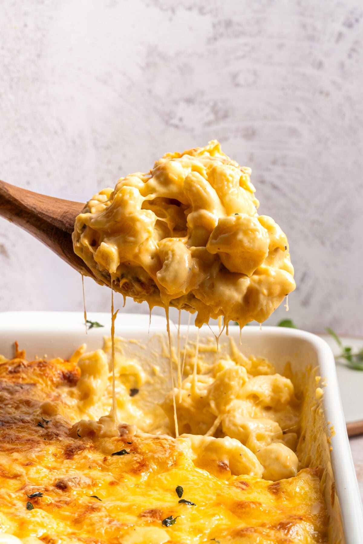 Spoonful of creamy baked macaroni and cheese with a cheese pull.