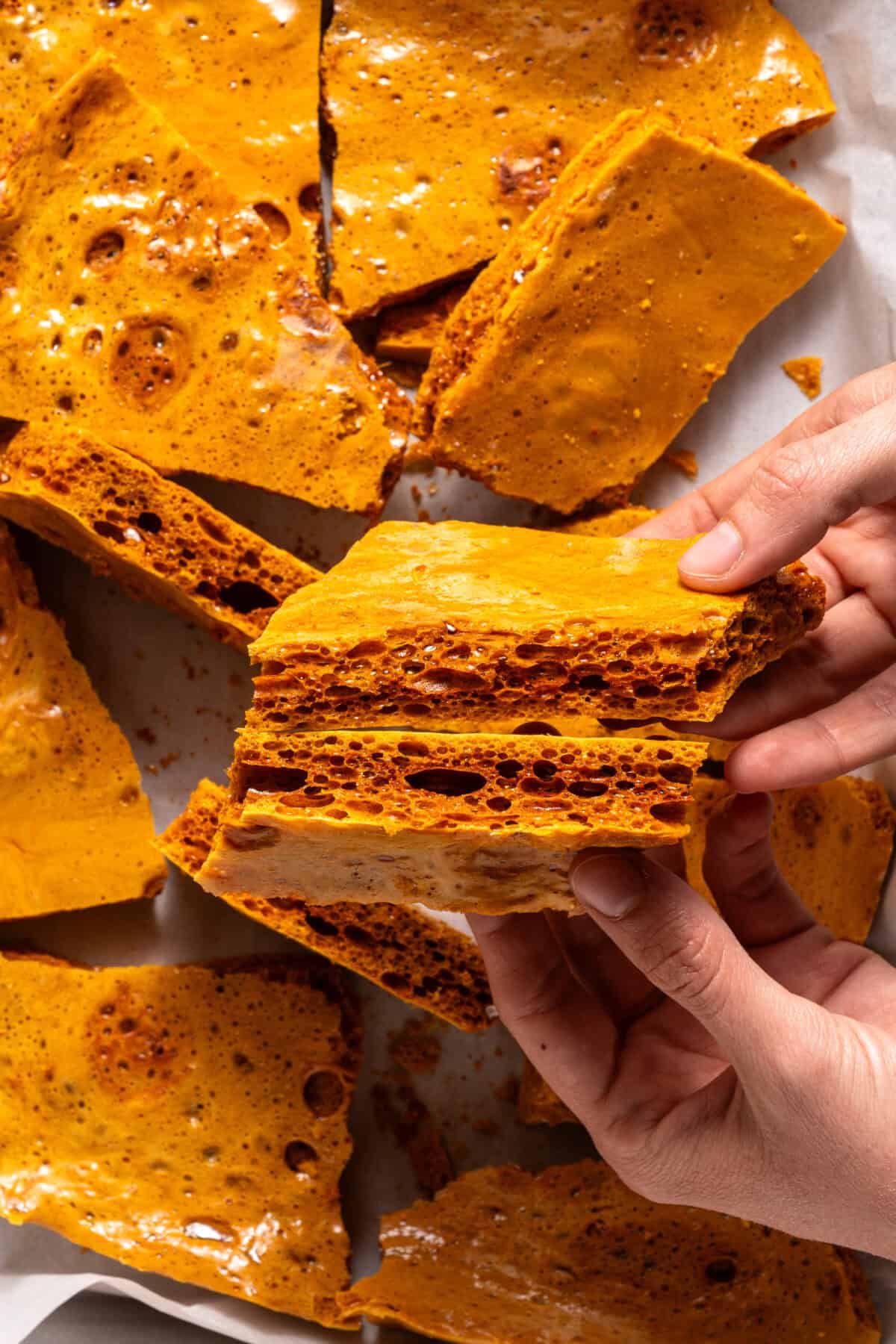 Hands breaking apart Honeycomb candy.