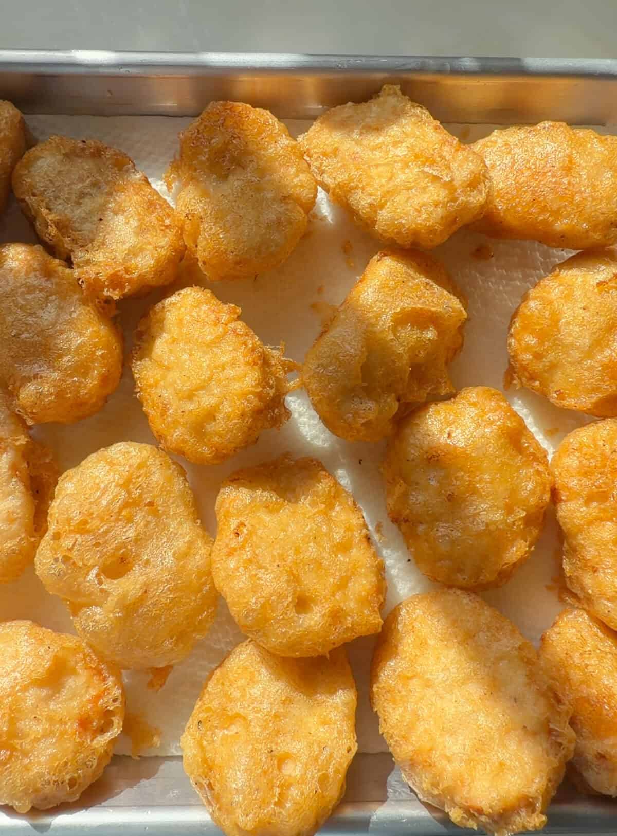 शीट ट्रे पर घर का बना चिकन नगेट्स।