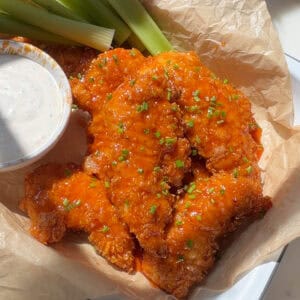 Hot Honey Buffalo Chicken Tenders with celery sticks and buttermilk ranch.