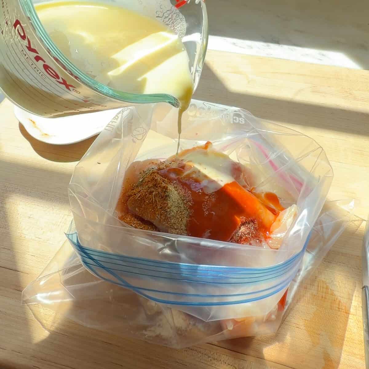 Buttermilk added to chicken tenders in storage bag.
