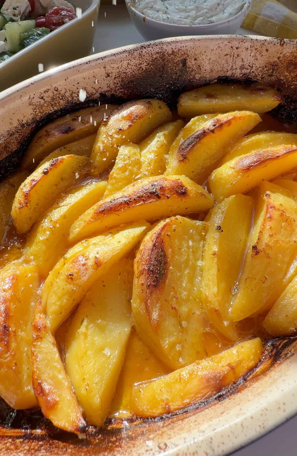 Flakey sea salt being garnished on Greek Lemon Potatoes.