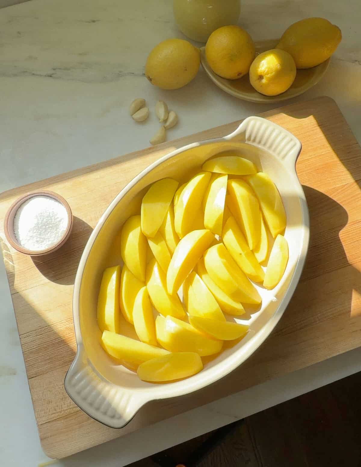 Potato wedges arranged in baking dish.
