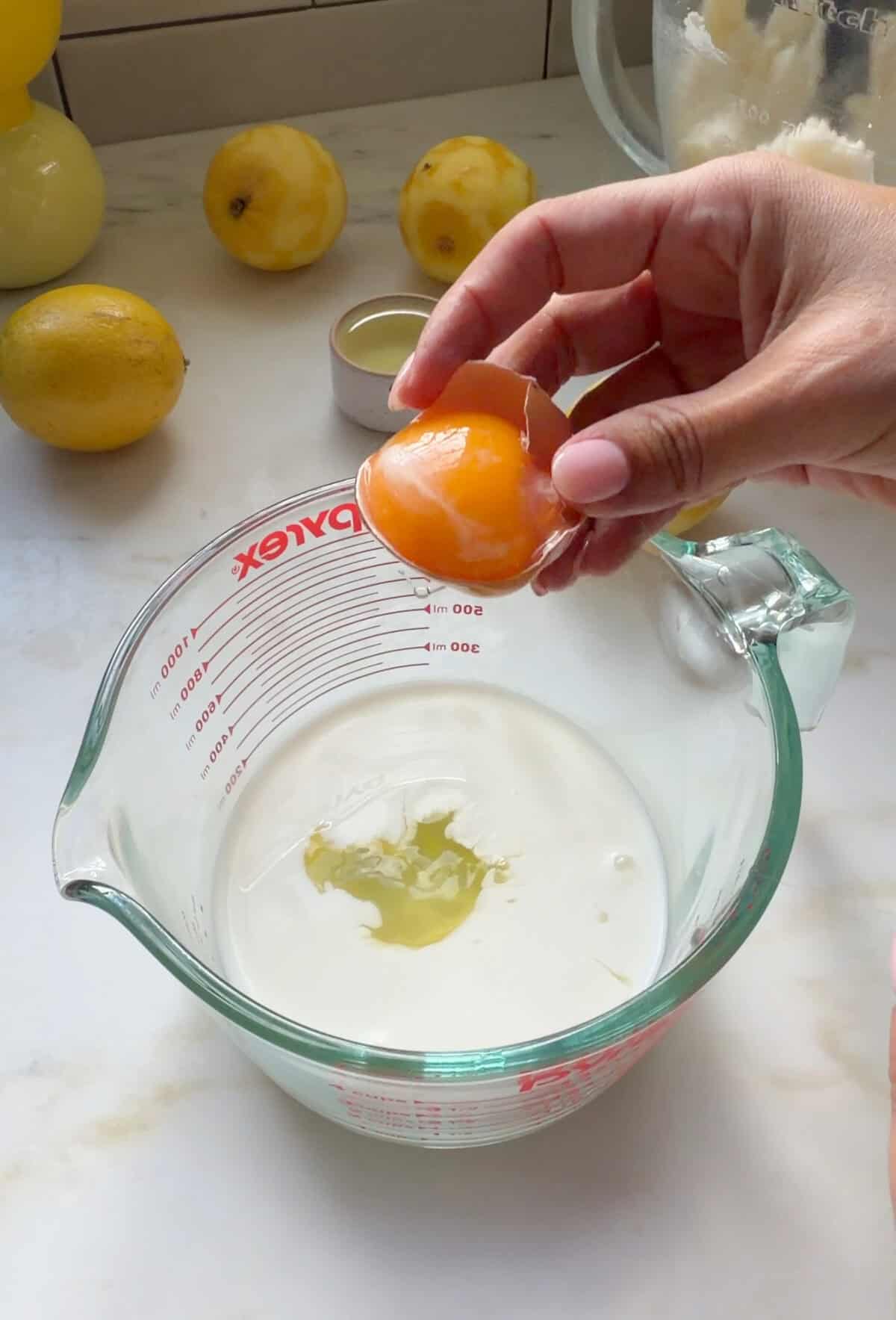 Egg whites being mixed with milk in a measuring cup.