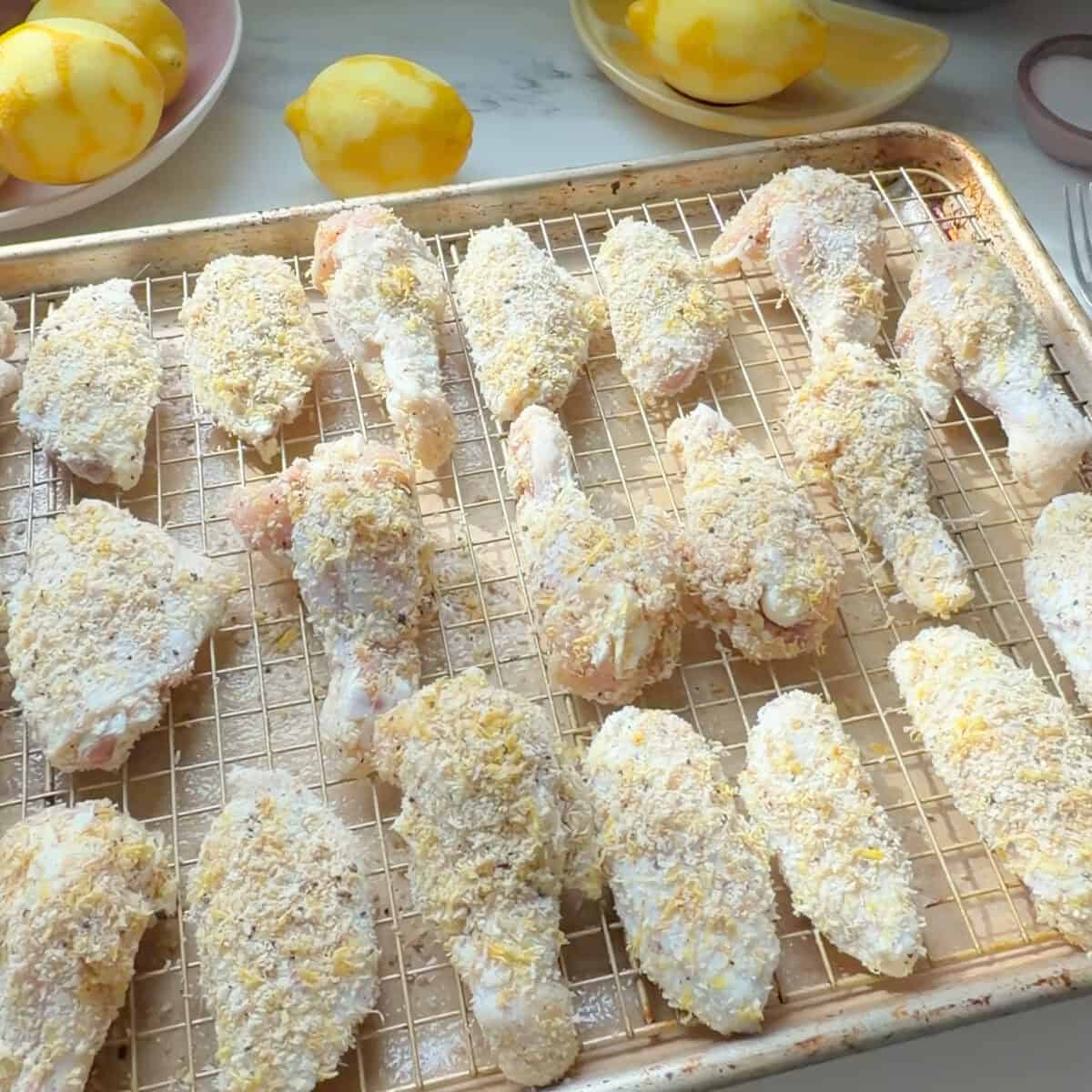 Lemon pepper coated wings on sheet tray.