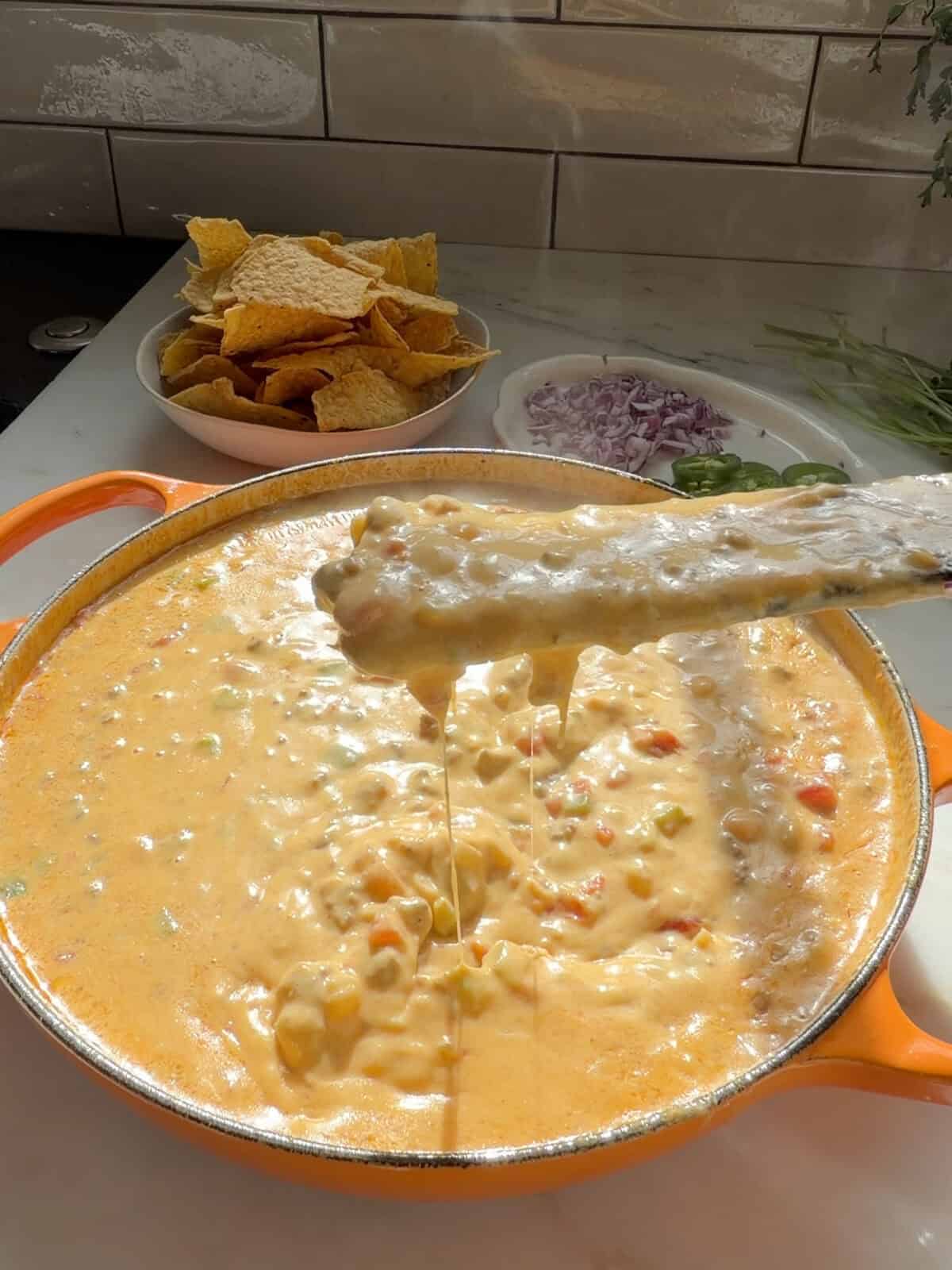Spatula stirring rotel dip in pot.