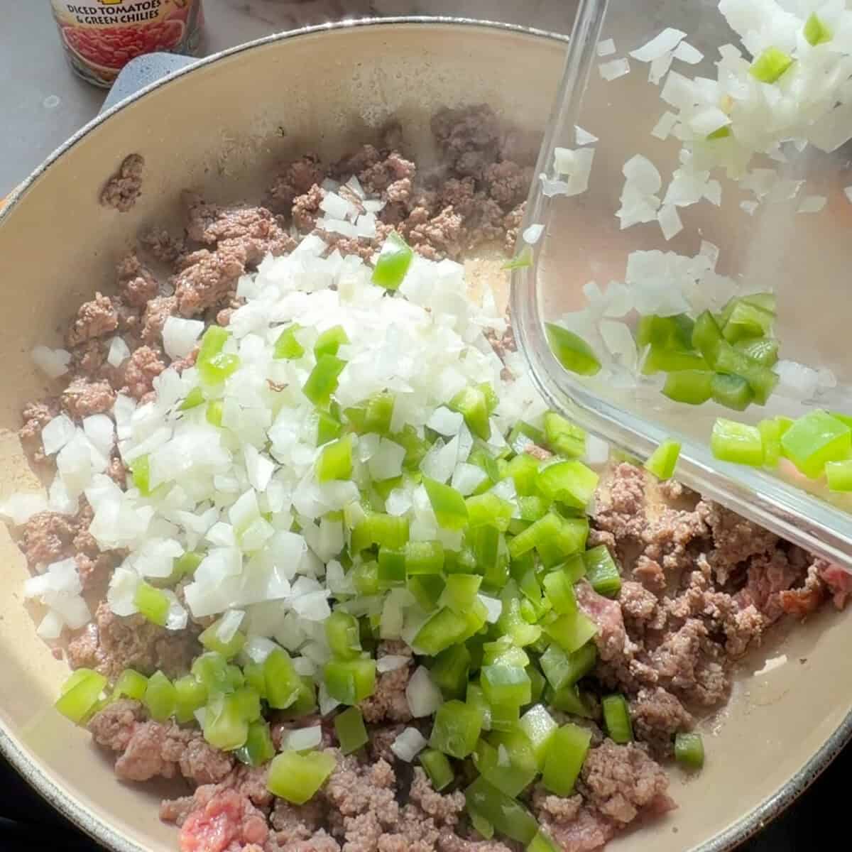 Onions, peppers, and ground beef in pan.