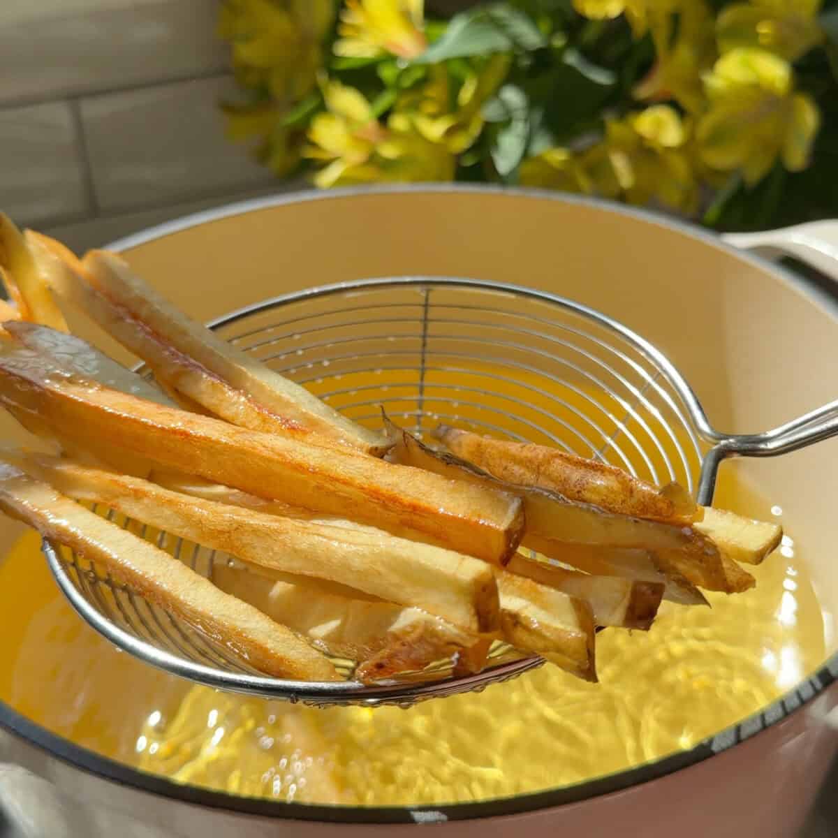 Crispy fries coming out of hot oil.