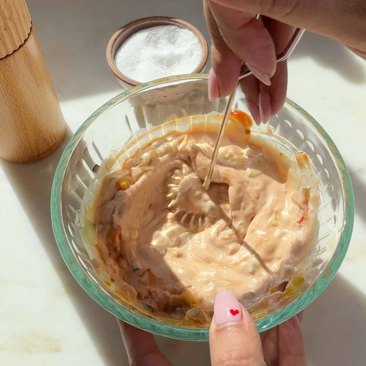 Whisking homemade burger sauce in bowl.