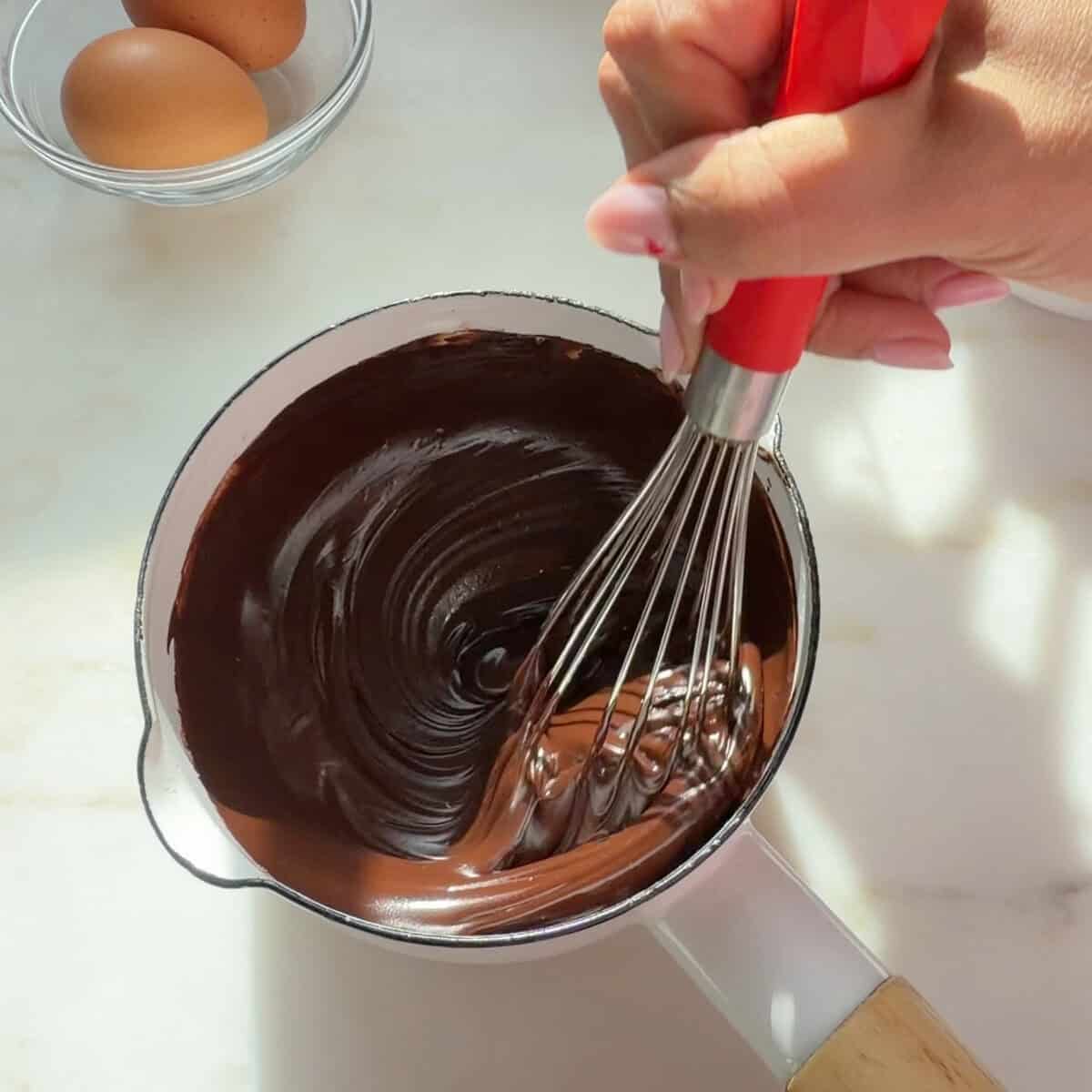 Whisking melted chocolate and butter.