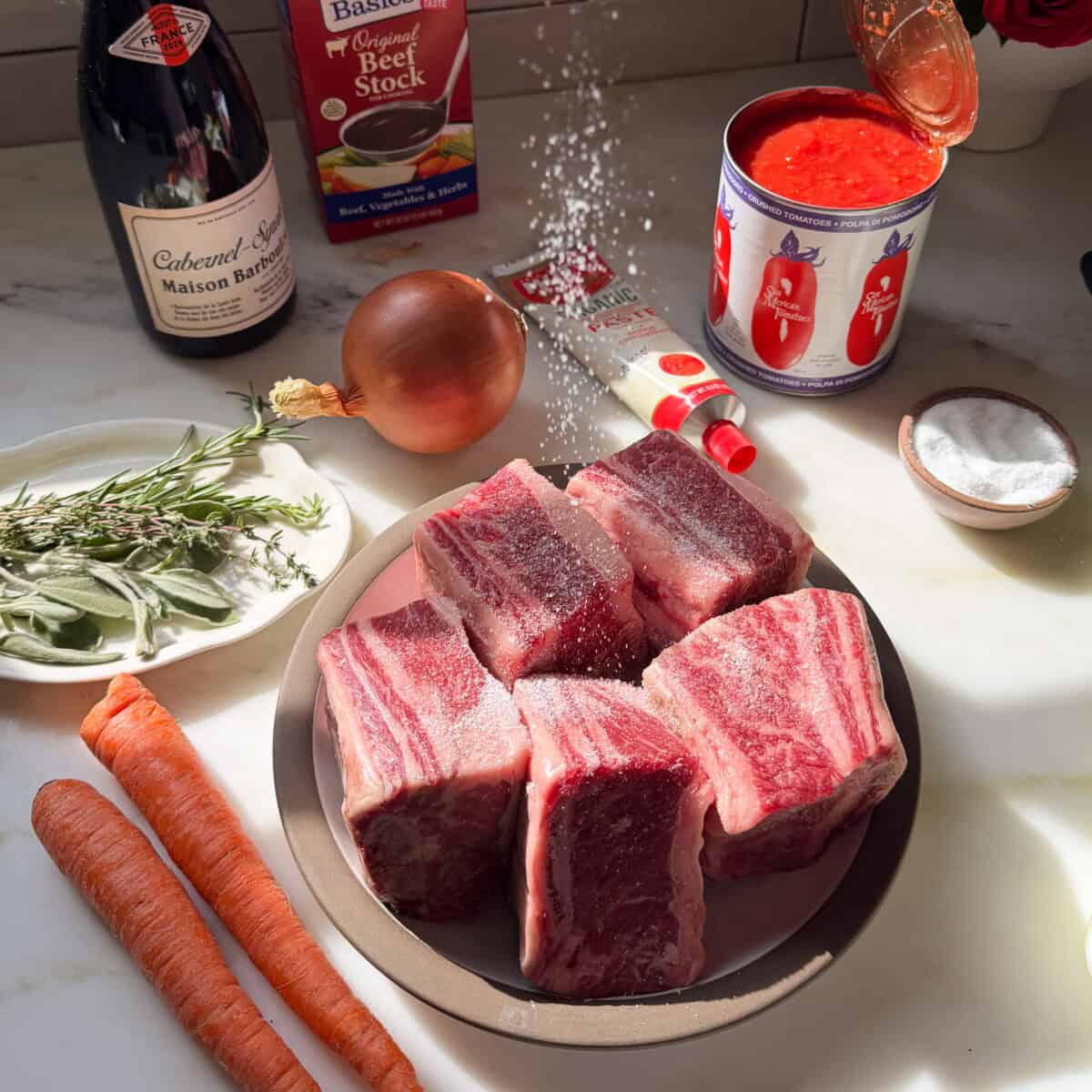 प्लेट में छोटी पसलियाँ नमकीन की जा रही हैं।